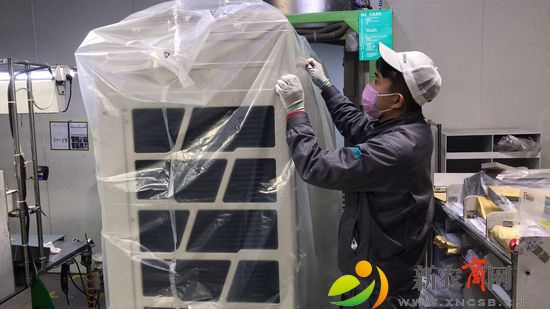 杨威在青岛海信日立空调系统有限公司包装车间对空调进行包装.jpg