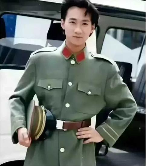 黄家驹身穿军装站在体育馆前的留影.jpeg