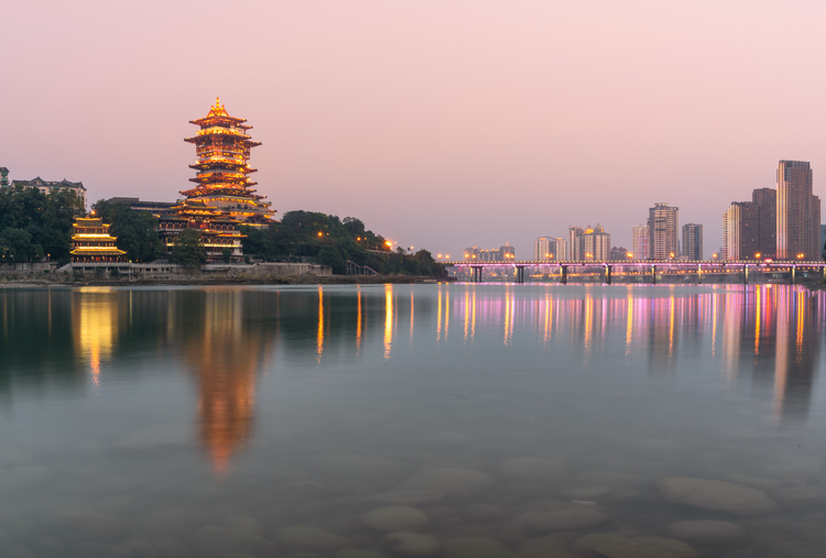 中国四川省绵阳市涪江畔的越王楼仿古建筑和城市现代建筑夜景和江里的倒影