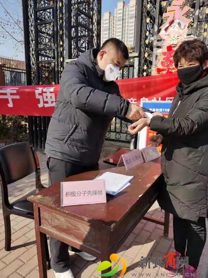 薛建凯在执勤点为出入小区人员测量体温.jpg