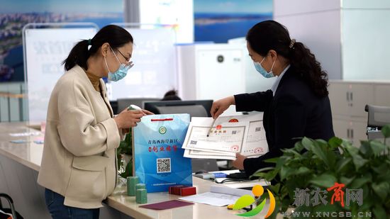 图为市民孙女士高在新区政务服务大厅高兴兴的领取“创业福袋”大礼包。今年以来，新区多出并举，克服疫情不利影响，截至10月中旬新设立市场主体共计67699户，同比增长43.30%。（胡全福 摄）.jpg