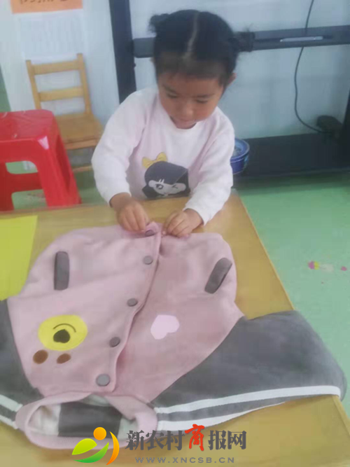 明村镇中心幼儿园小一班开展“我会叠衣服”活动