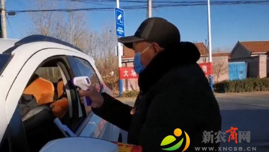 徐洪金正在测量出入人员体温.jpeg