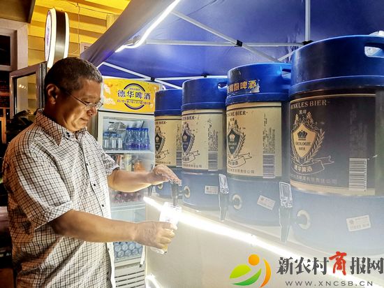 青岛西海岸新区金沙滩啤酒城德华精酿啤酒吧负责人为游客打酒（李涛）.jpg