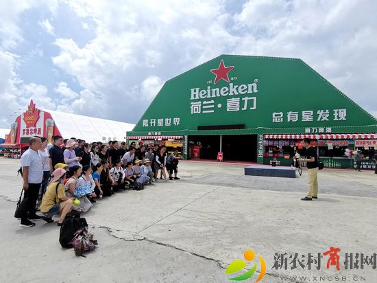 游客在青岛西海岸新区金沙滩啤酒城荷兰喜力啤酒大篷前拍照。（李涛）.jpg